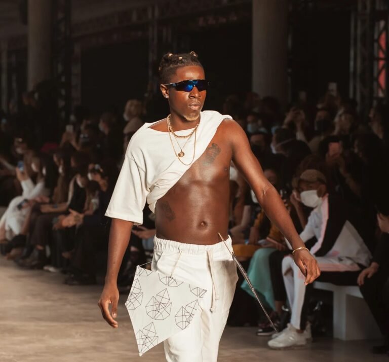 Look branco assimétrico com óculos escuros na passarela da Mile Lab.