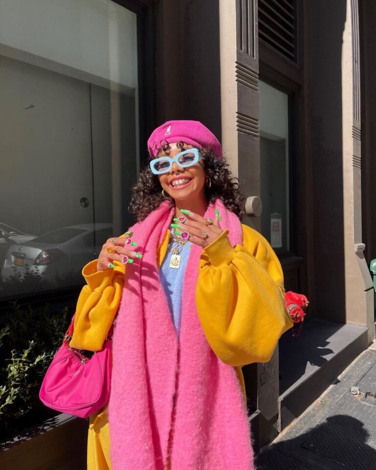 Look colorido com casaco amarelo, estola rosa, boina e bolsa rosa.