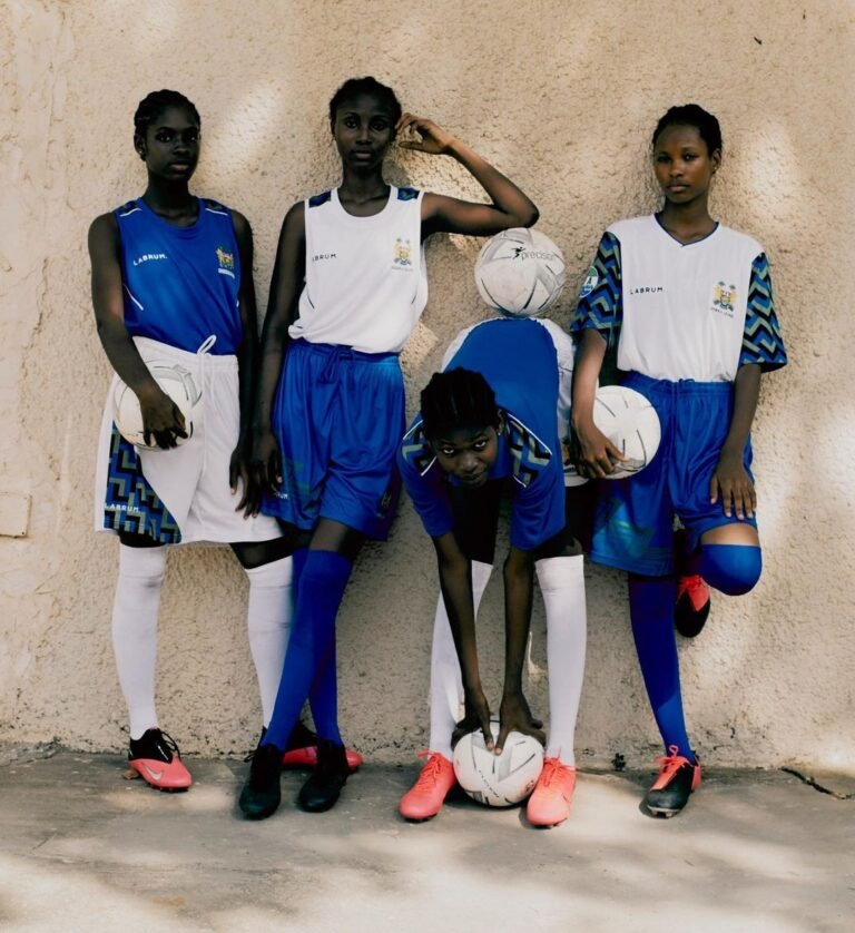Quatro modelos da Labrum com roupas esportivas brancas e azuis diante de uma parede.