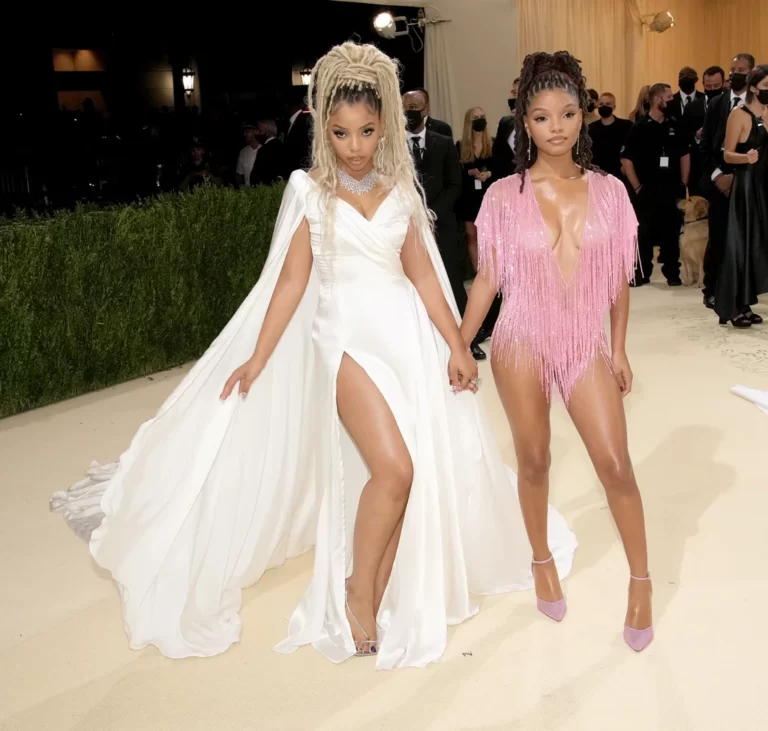Dois vestidos de gala, um branco com cauda e outro rosa, no Met Gala 2021.