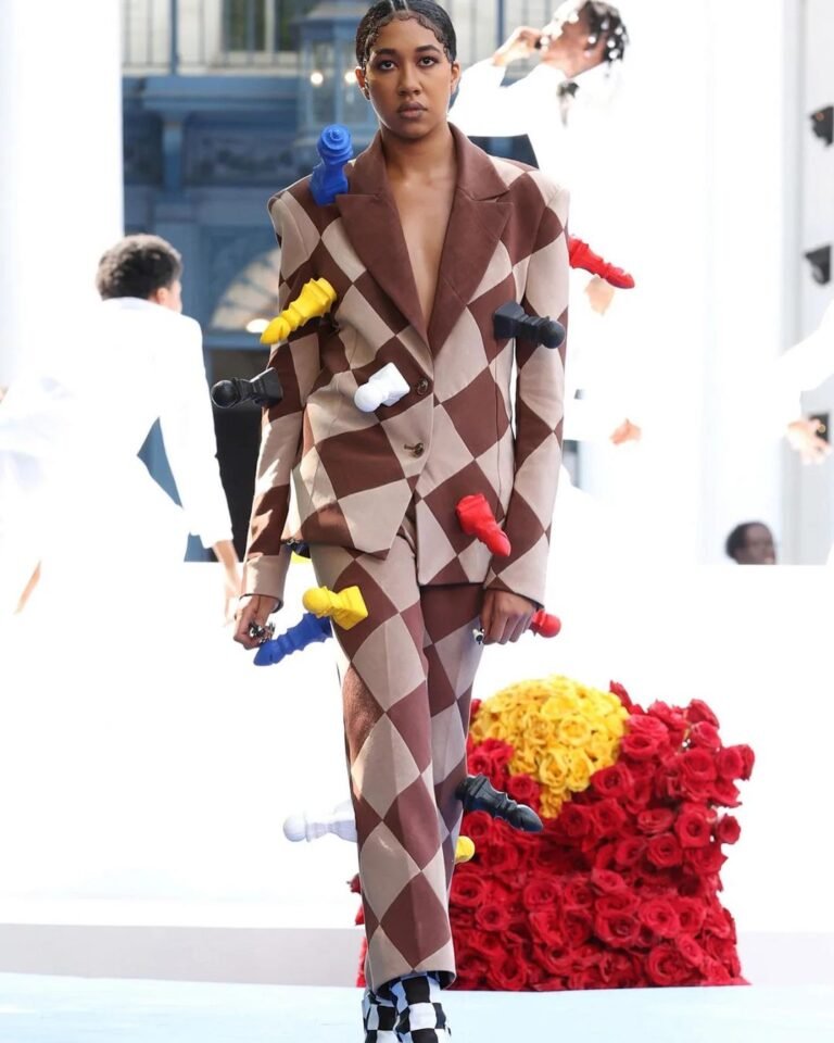 Conjunto geométrico da Pyer Moss com pequenas peças coloridas presas à roupa.