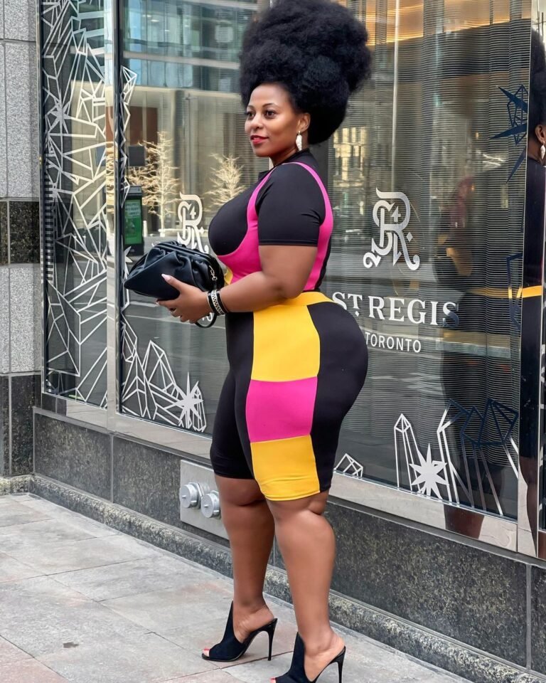 Vestido justo com blocos de cor em preto, rosa e amarelo, usado com salto alto.