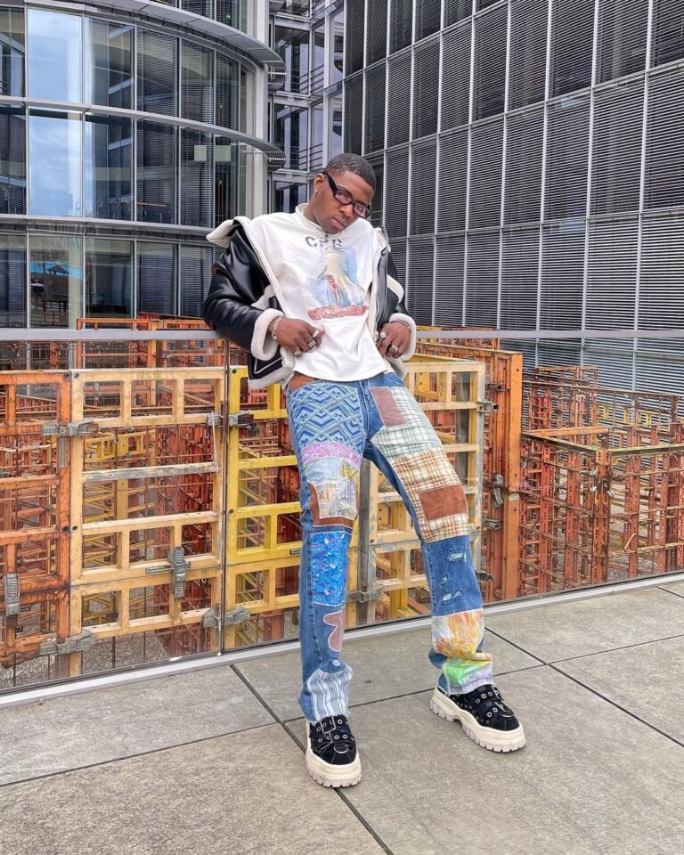 Jeans estampados combinados com blusa clara e tênis em uma fotografia na rua.