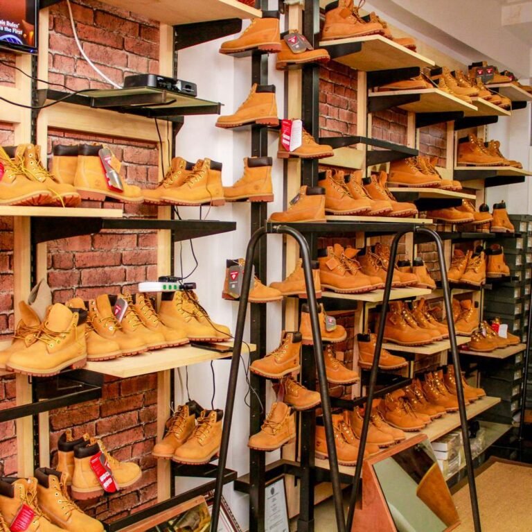 Prateleiras de uma loja com vários pares de botas Timberland amarelas.