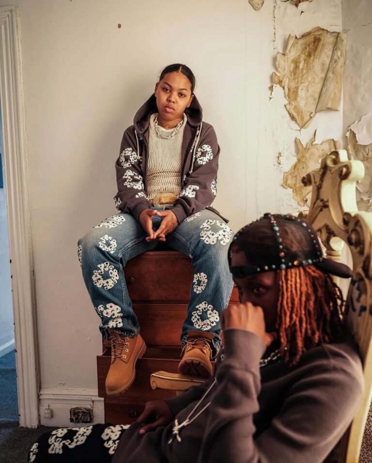 Look com jaqueta marrom e calça estampada, acompanhado de botas Timberland.