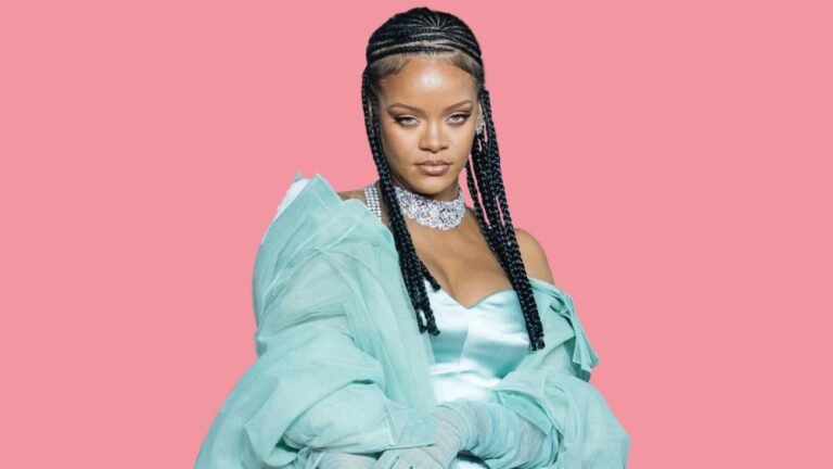 Rihanna com casaco azul-claro e tranças diante de um fundo rosa.