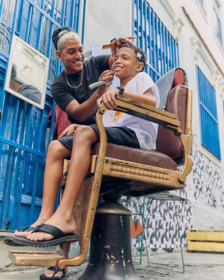 Duas pessoas com sandálias Kenner sentadas em uma cadeira na rua.