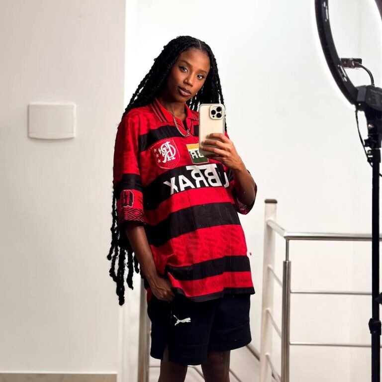Camiseta do Flamengo combinada com bolsa transversal e tranças longas.