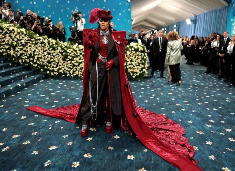 Look vermelho com chapéu e longa cauda no Met Gala 2025.