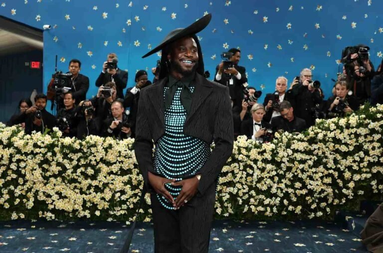 Shaboozey com chapéu preto e acessórios azuis no Met Gala 2025.