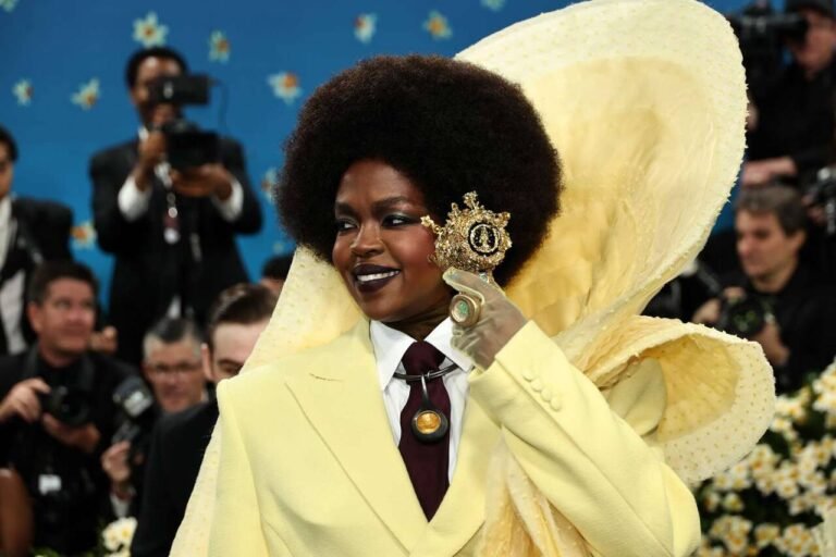 Look amarelo com gravata e um adorno amplo atrás da cabeça no Met Gala 2025.