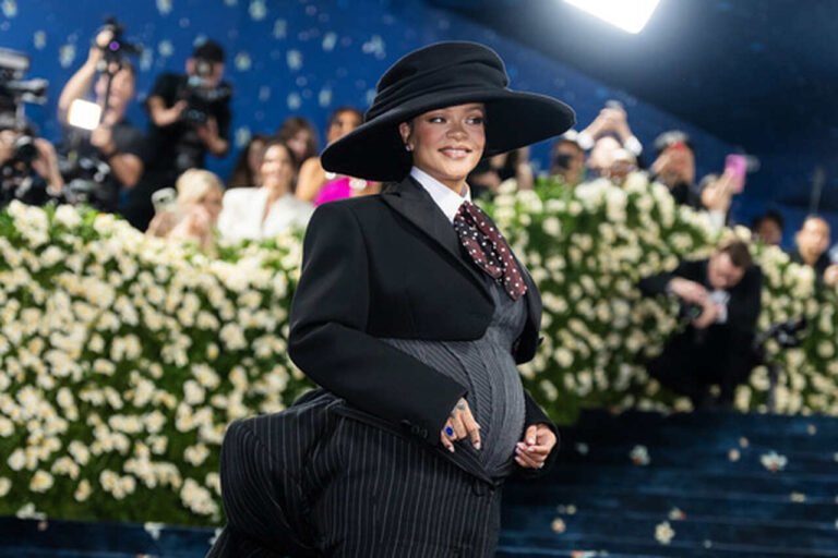 Rihanna com chapéu de aba larga e look de alfaiataria escuro no Met Gala 2025.